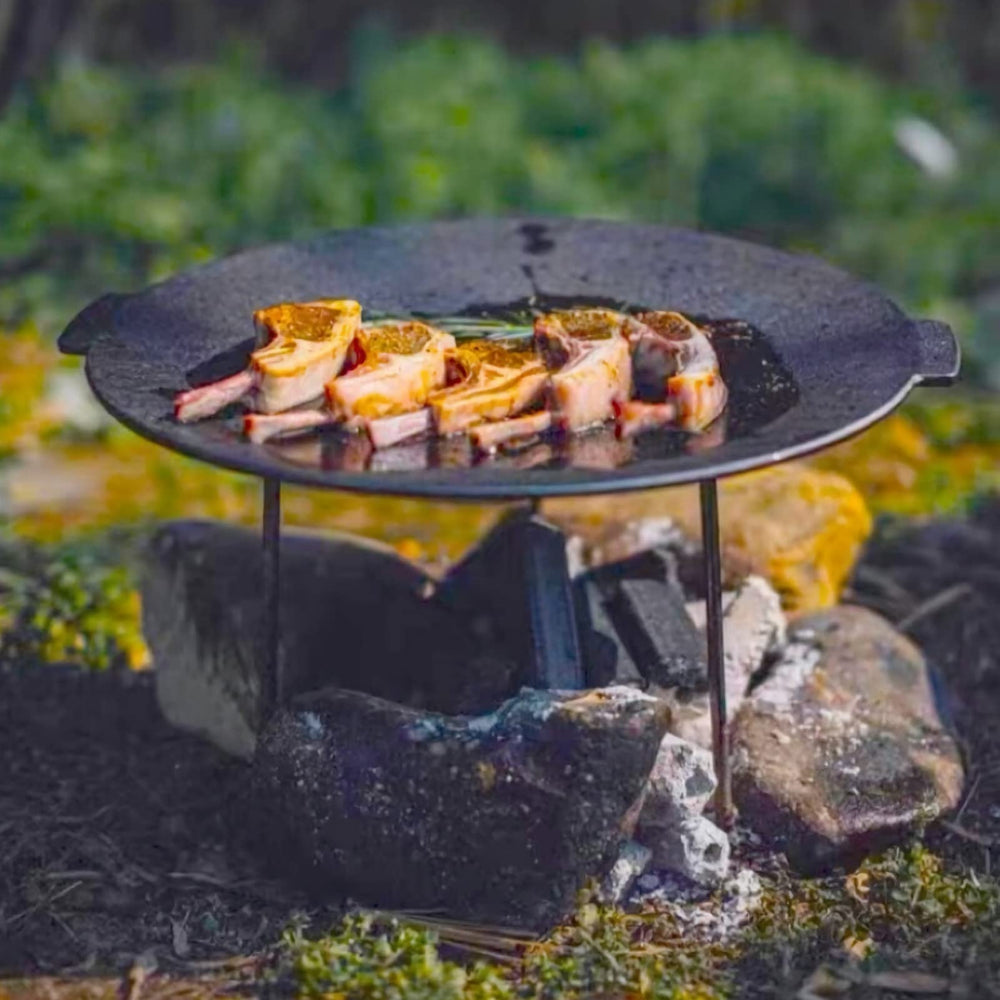Veryard in use over campfire with food cooking to display versatility and outdoor performance