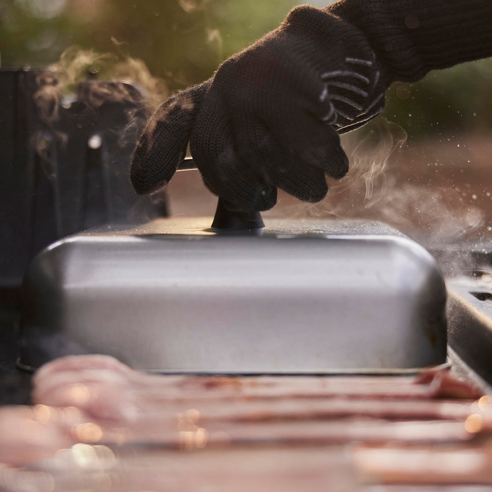 Weber dome covering four burgers to show scale and efficient cooking capacity