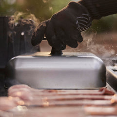 Weber dome covering four burgers to show scale and efficient cooking capacity