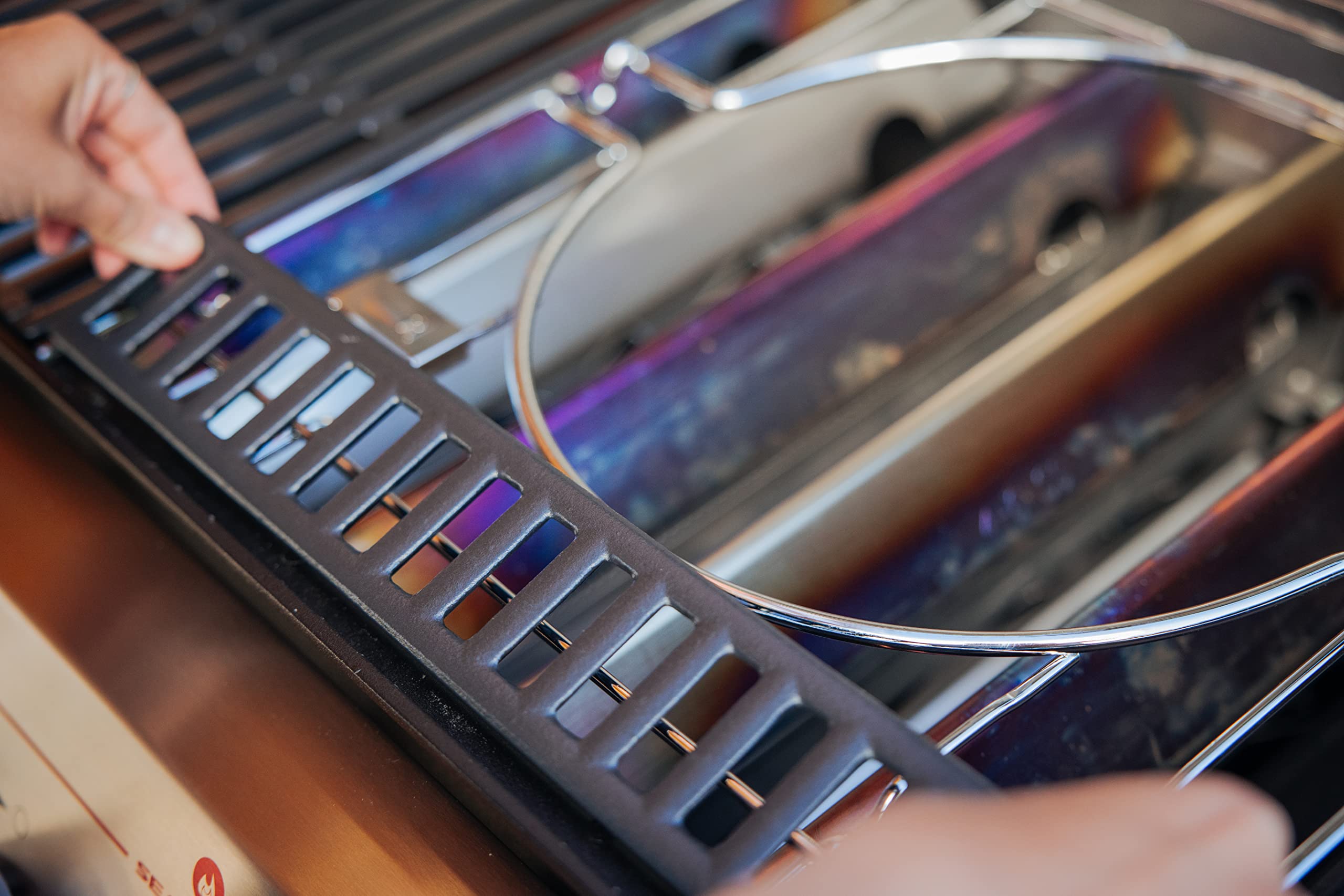 Close view of the frame fitting beneath the right-side grate on a Weber Genesis grill for stability