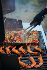 Weber basket with roasted vegetables inside showing caramelized color and easy tossing benefit