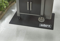 Weber floor protection mat beside grill for size comparison and full coverage benefit