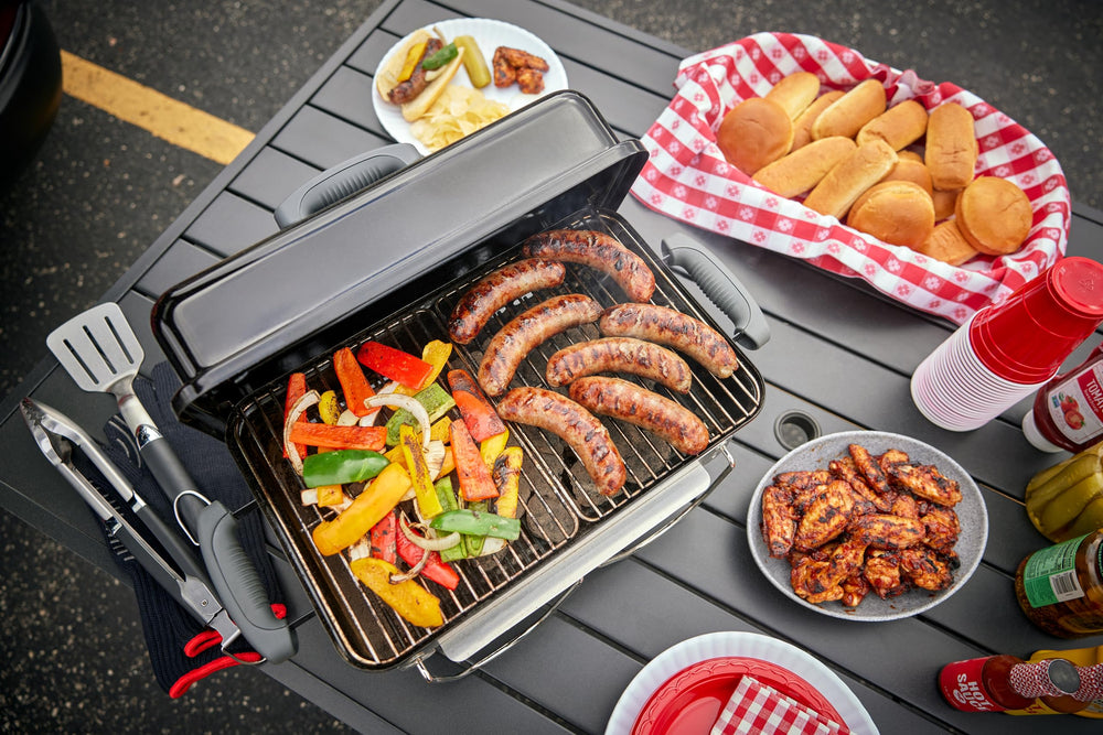 Weber grill in campsite setting showing outdoor cooking capability and lifestyle appeal