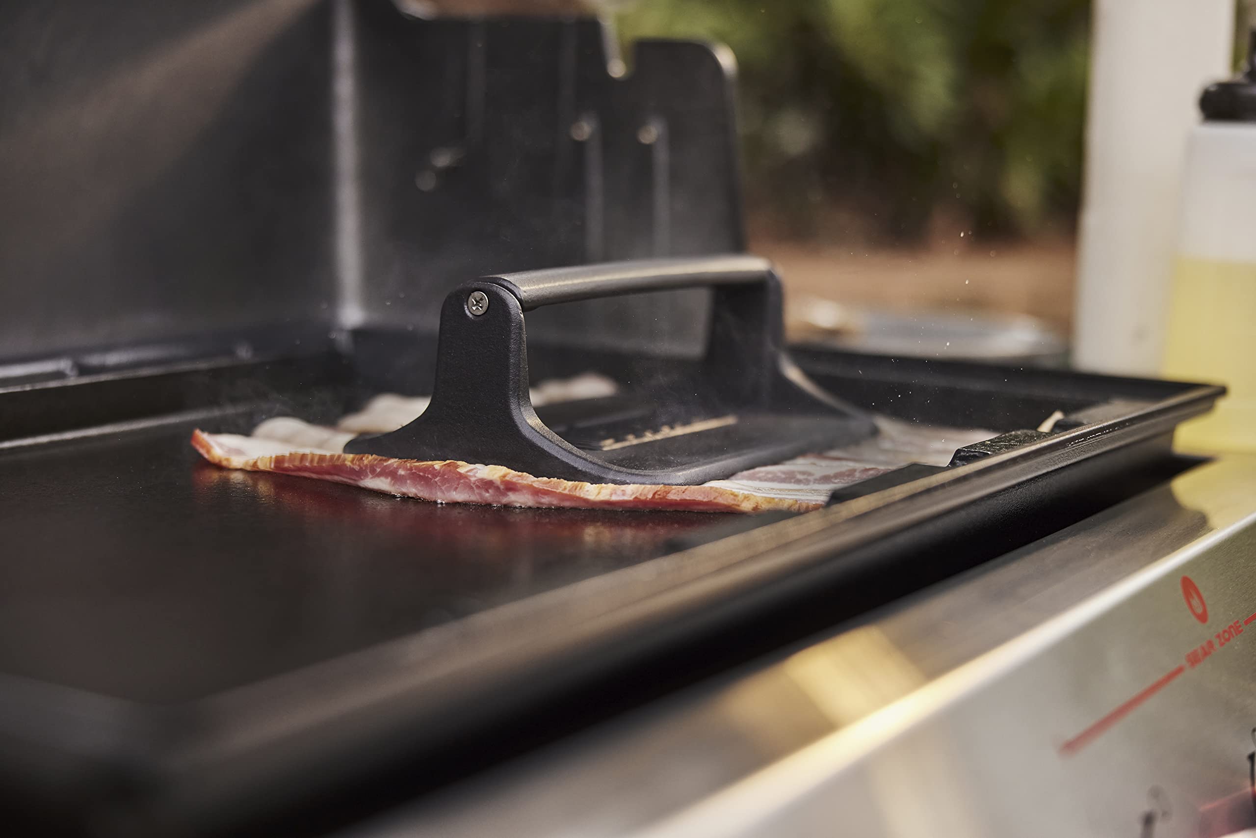 Weber press in use flattening bacon for even crisping and faster cook times