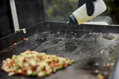 Weber griddle scraper edge view showing effective grease and residue removal