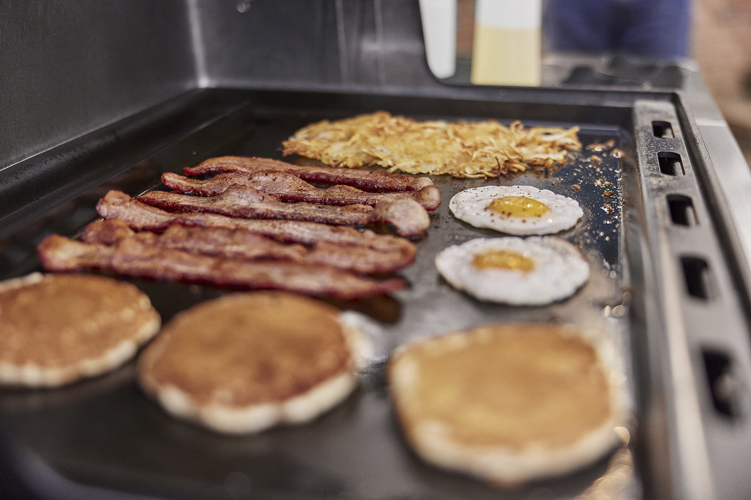Weber griddle with size comparison to spatula showing full‑size capacity for family meals