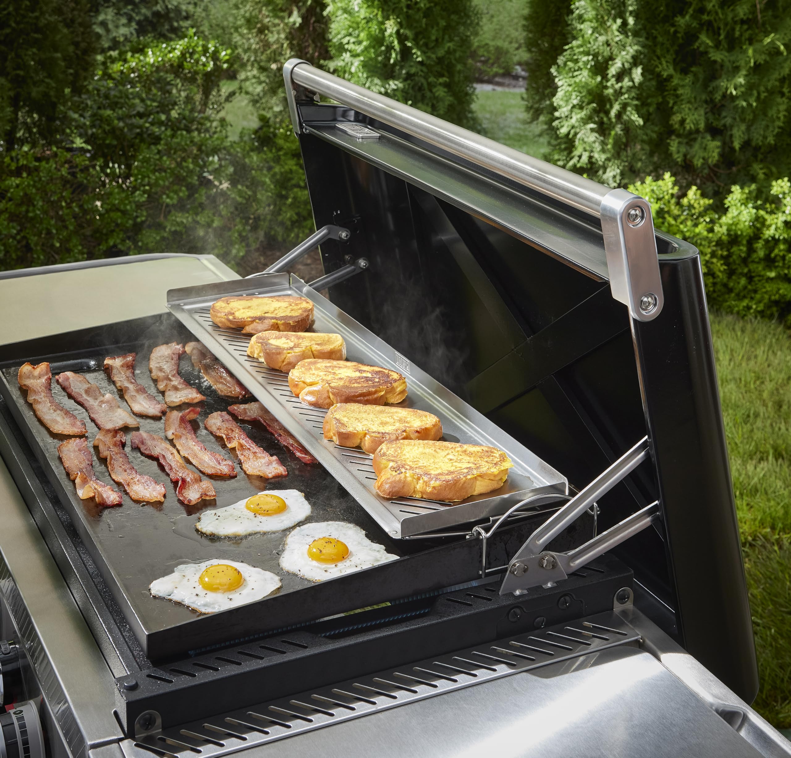 Weber warming rack beside a hand for scale showing roomy surface and practicality