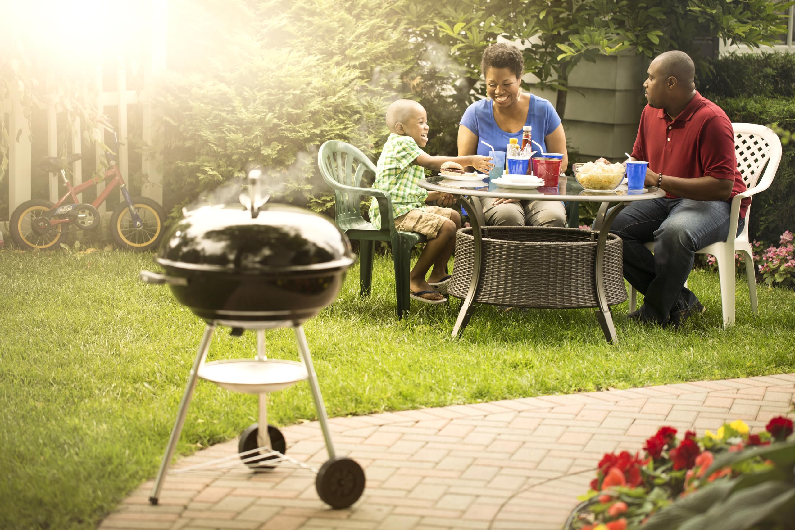 Weber Jumbo Joe next to chair to show compact 22-inch scale and porch-friendly size