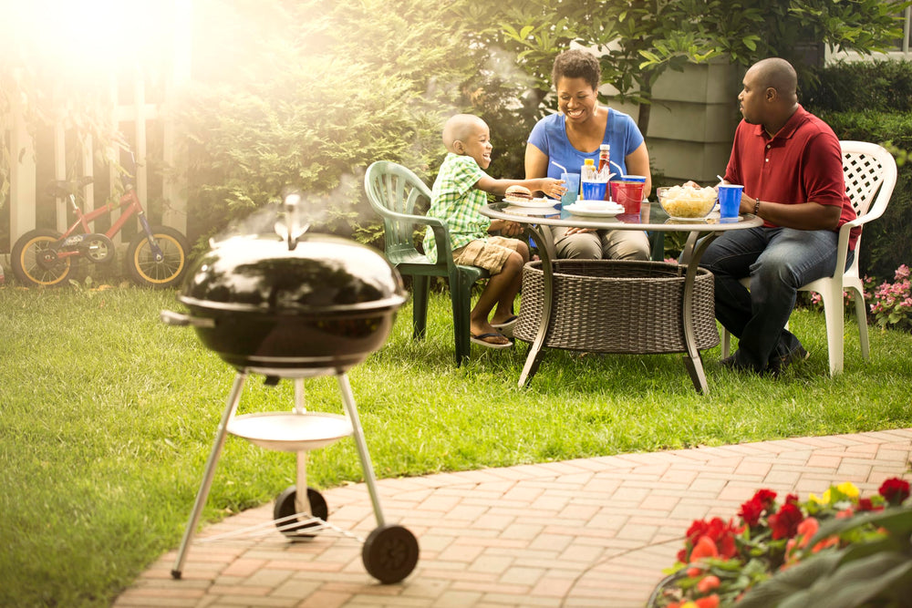 Weber Jumbo Joe next to chair to show compact 22-inch scale and porch-friendly size