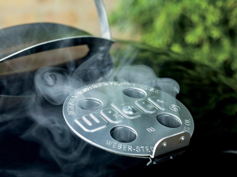Weber kettle in backyard lifestyle setting showing social grilling enjoyment