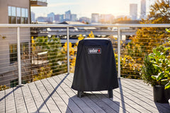 Weber Lumin cover strap attachment detail showing secure fastening to stand