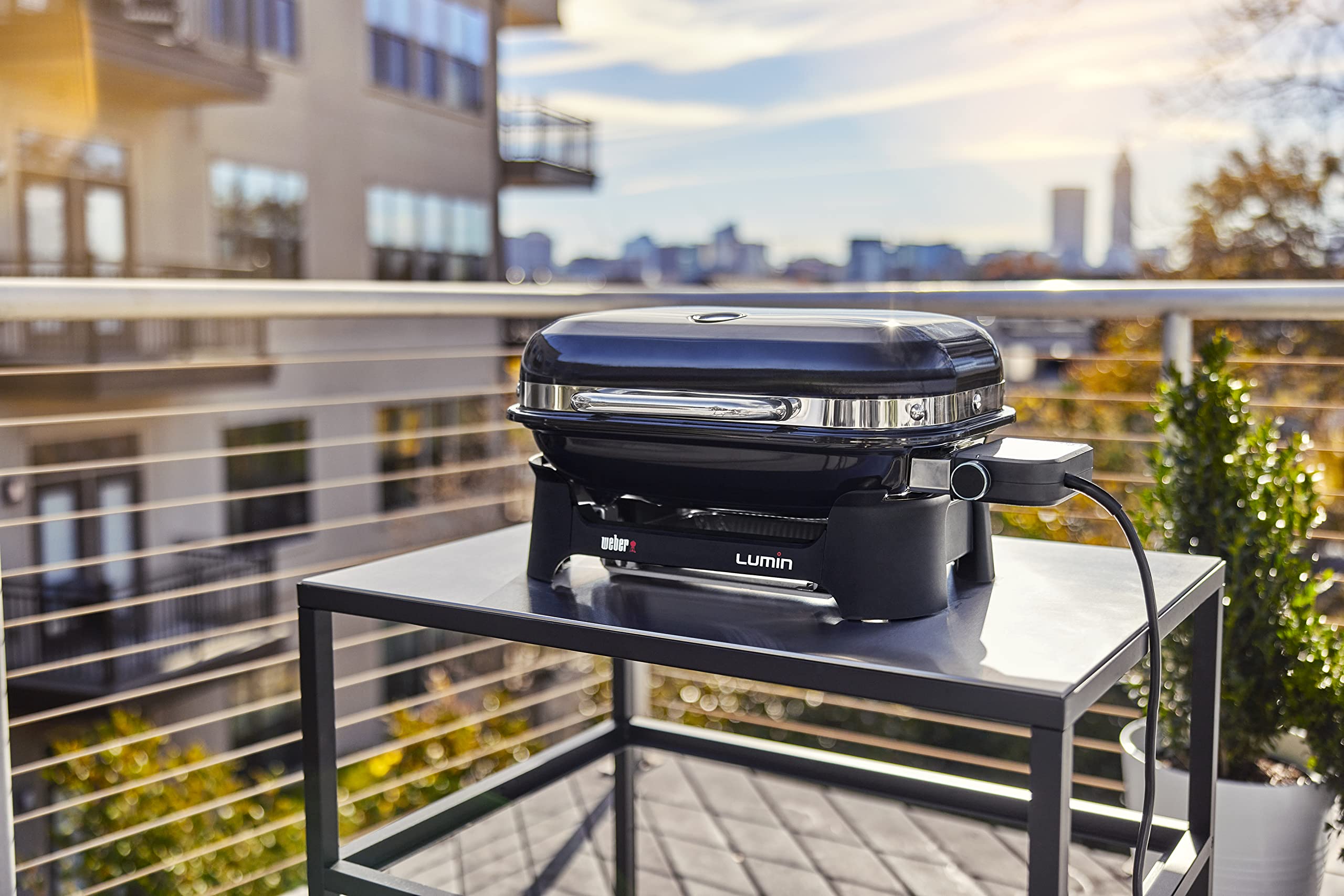 Weber Lumin on balcony with bonnet cover secured, protecting grill from elements