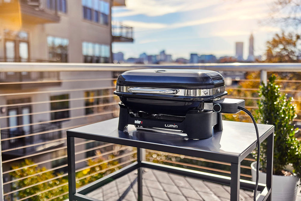 Weber Lumin on balcony with bonnet cover secured, protecting grill from elements