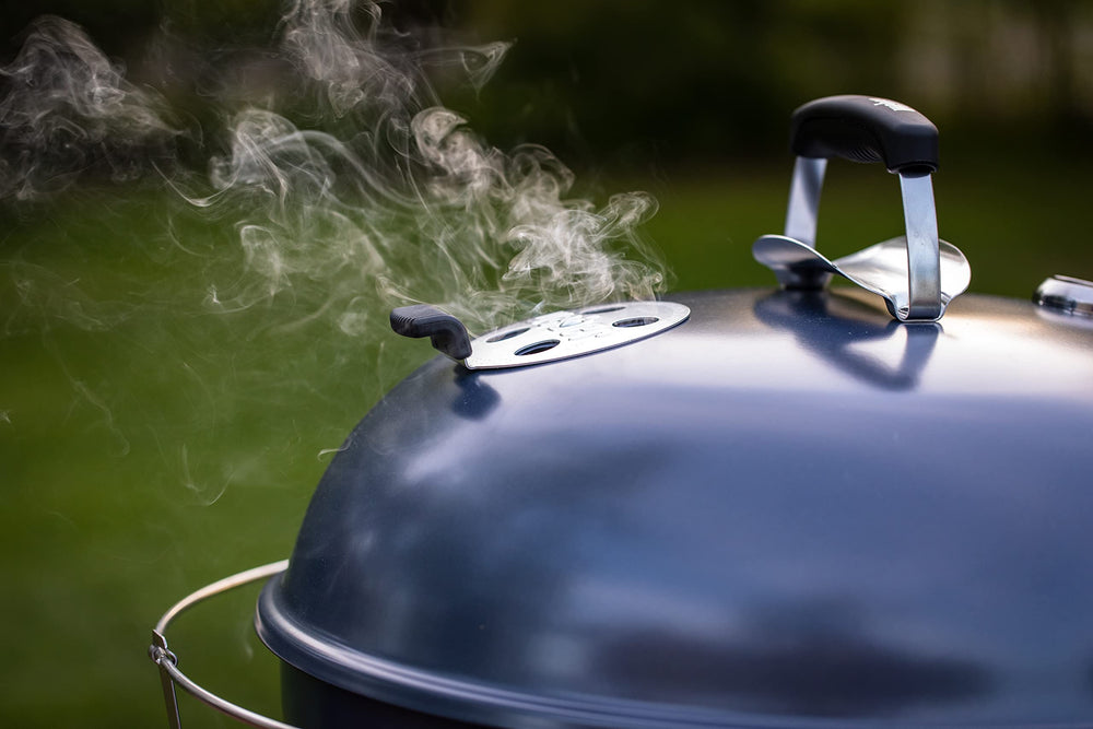 Weber Master-Touch in a backyard lifestyle setting serving family-style grilled food efficiently