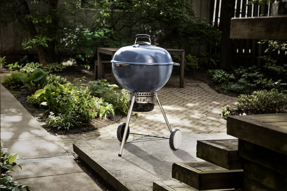 Weber Master-Touch tool hooks with spatula and tongs kept within reach for efficient grilling
