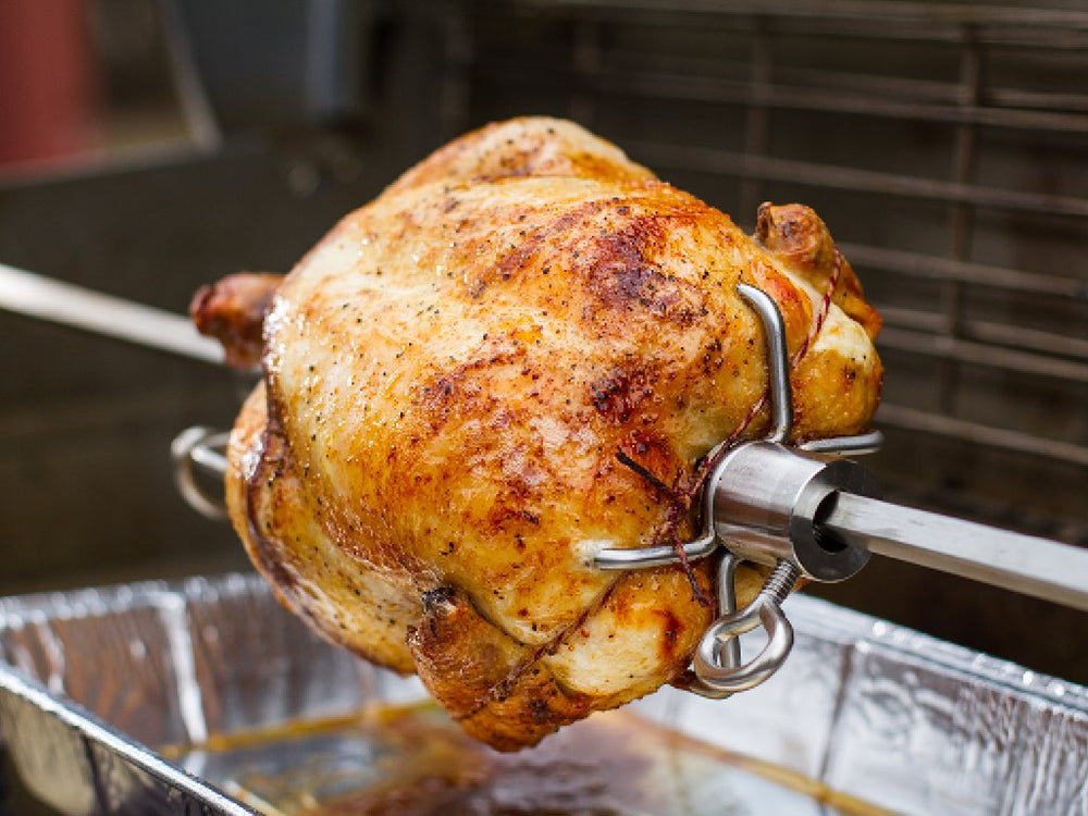 Weber rotisserie next to ruler for size comparison illustrating spit length and fit