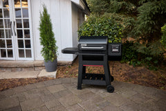 Weber Searwood table folded against grill to save space and protect surface