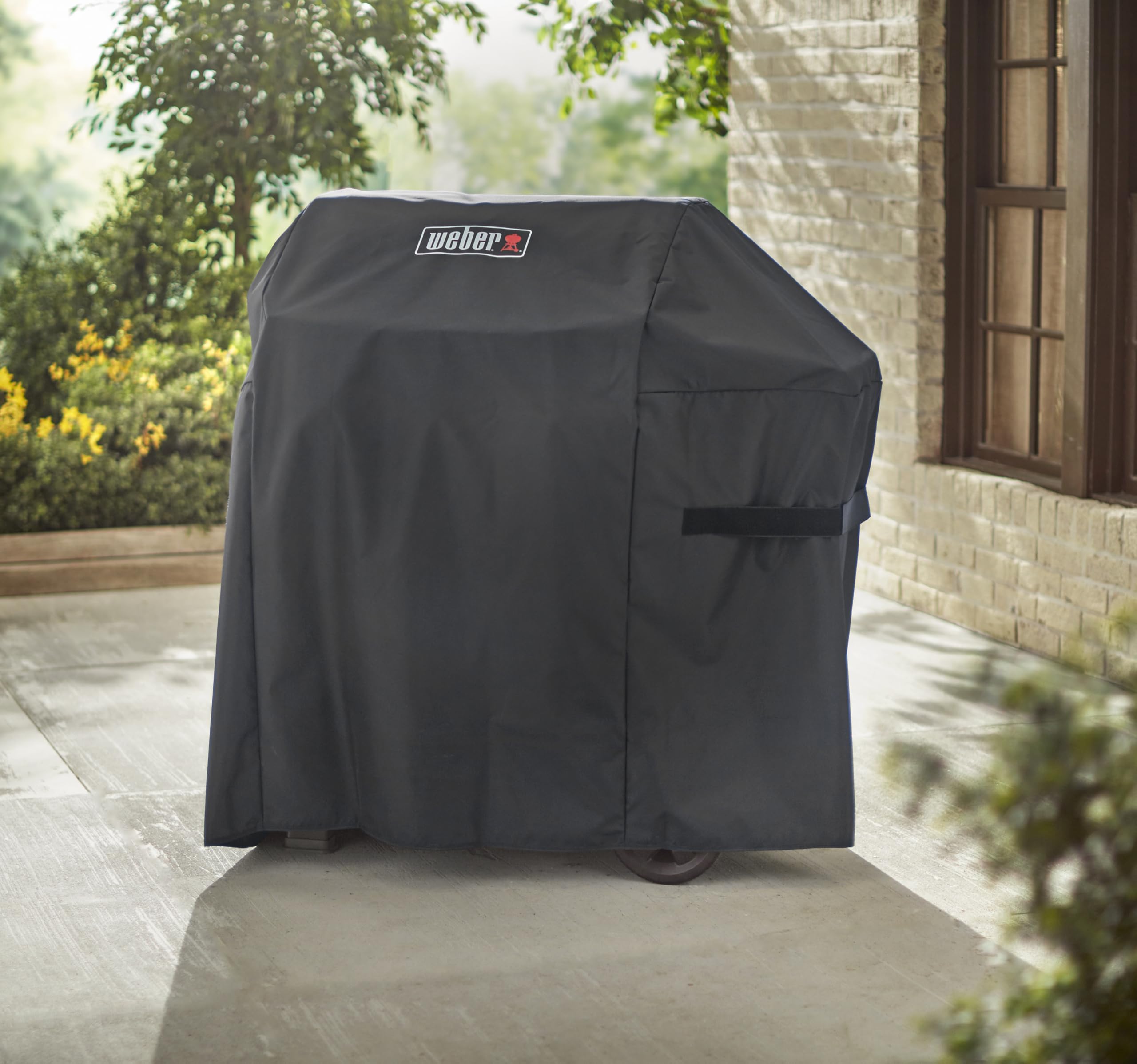 Weber cover next to patio chair showing scale and easy storage benefit