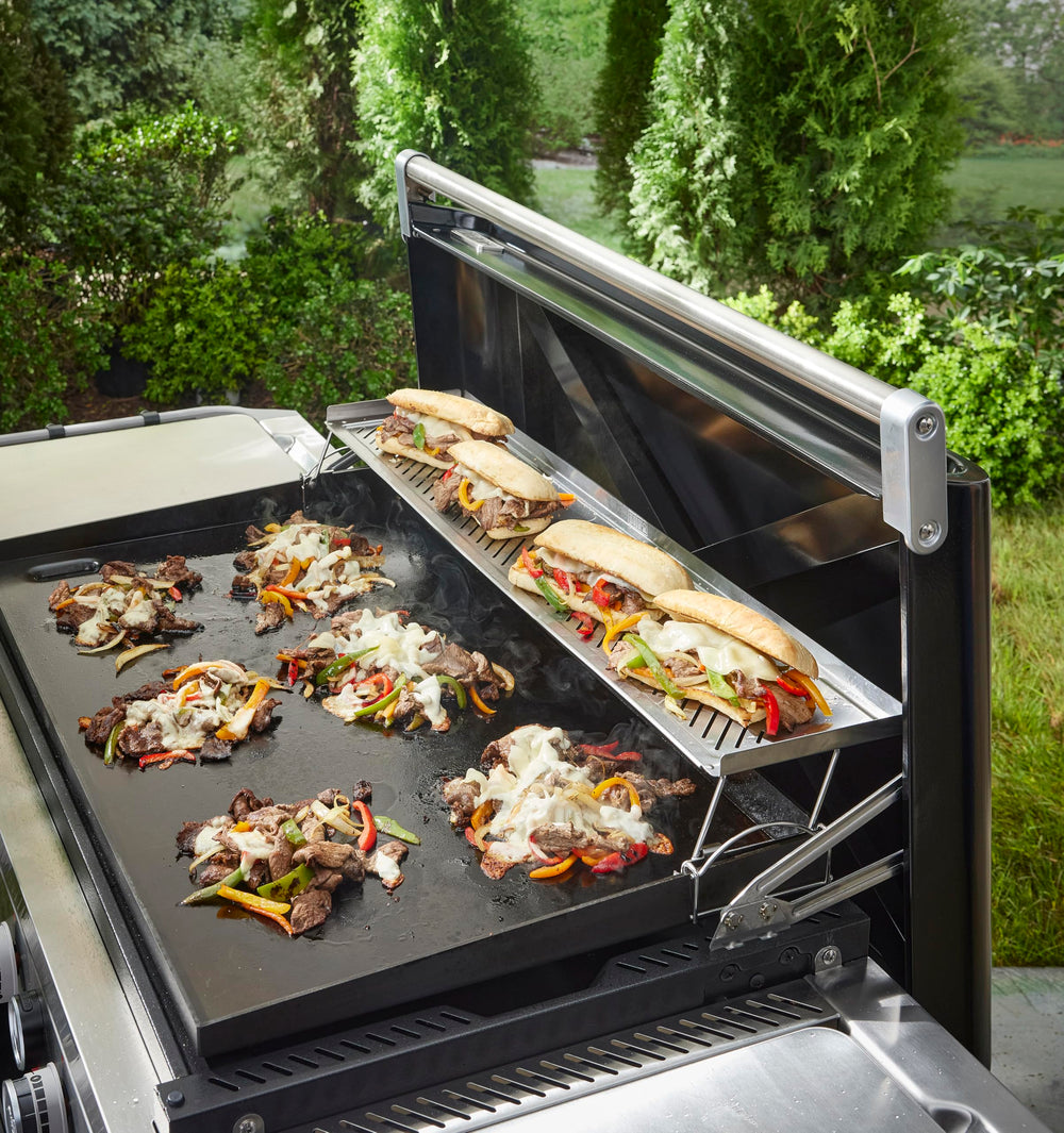 Weber warming rack holding tray full of scrambled eggs to keep food warm and ready
