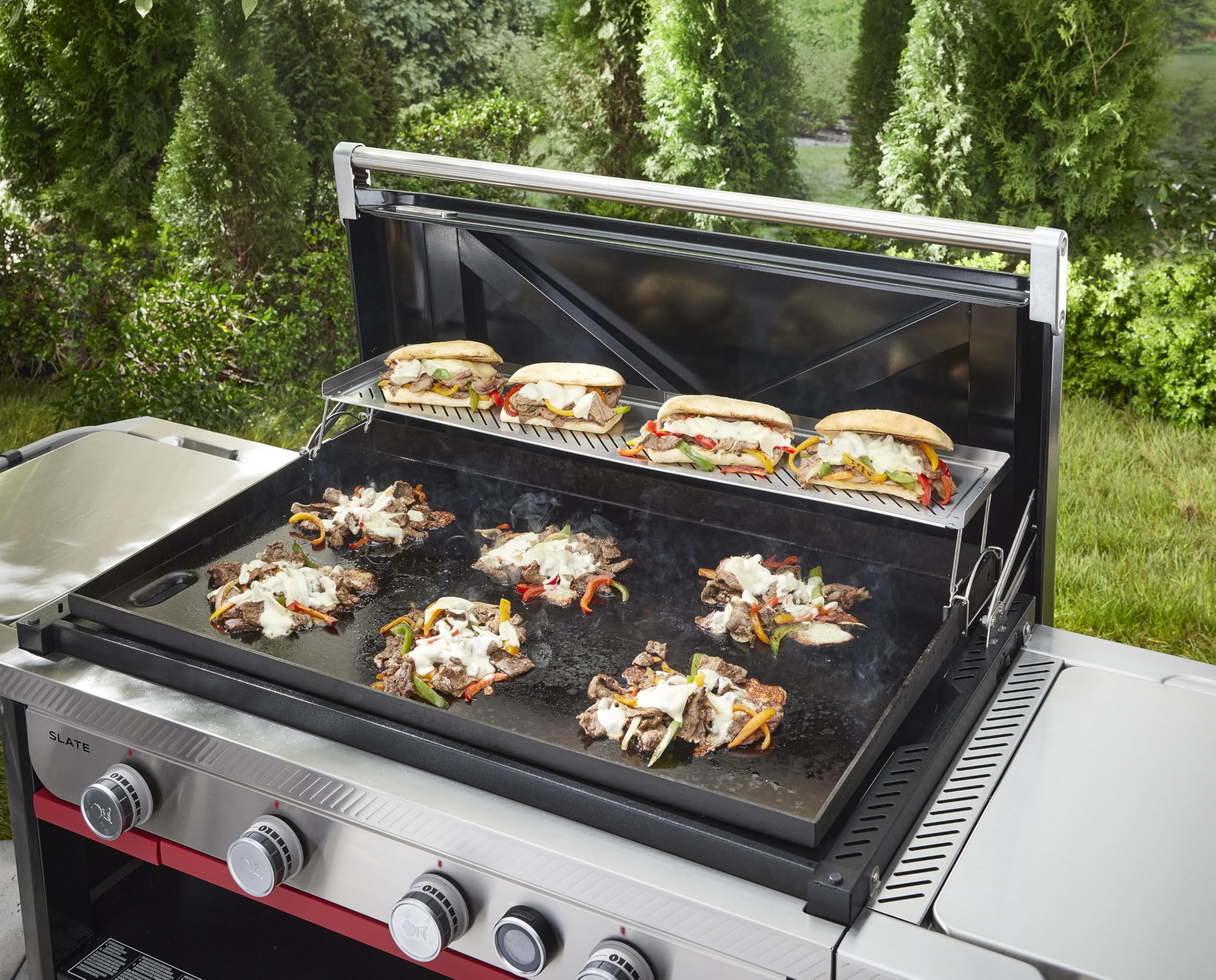 Weber warming rack in use toasting buns while freeing main griddle for searing