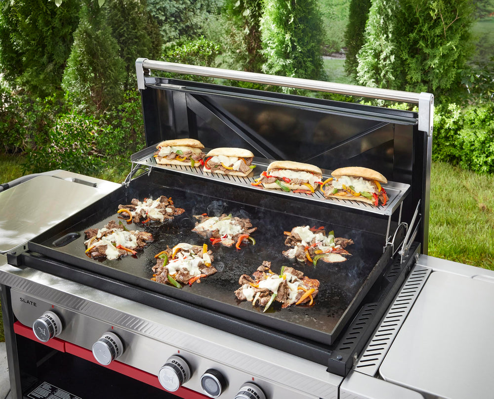 Weber warming rack in use toasting buns while freeing main griddle for searing