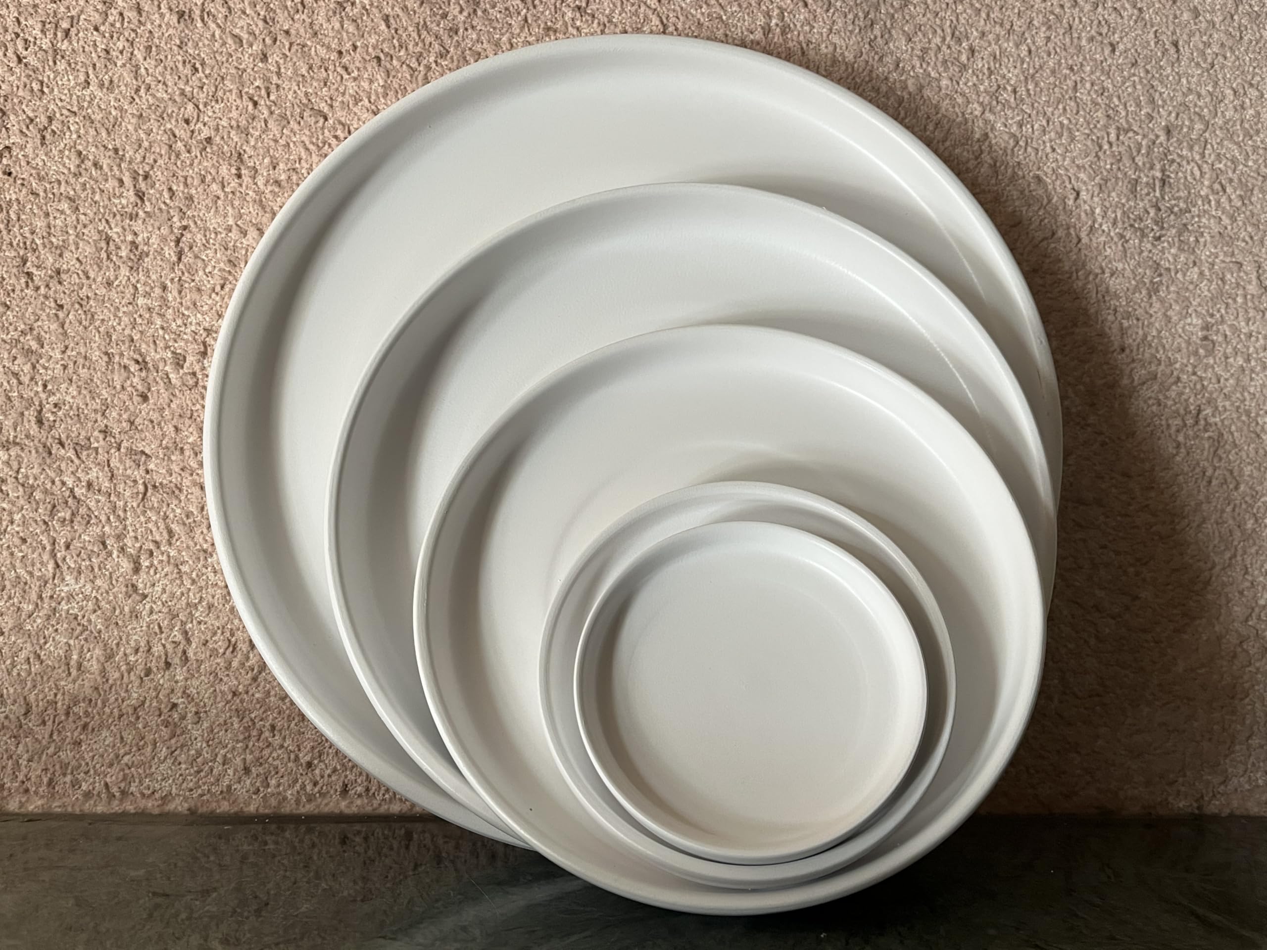 Woiida saucer with water pooling demonstrating catchment to protect floors