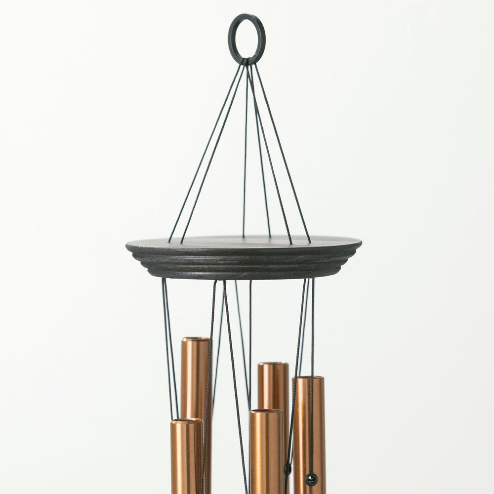 Woodstock Chimes in garden setting hanging near plants, brings peaceful music to outdoor spaces