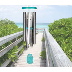 Woodstock Chimes displayed on a porch railing showing scale and tranquil outdoor decor benefit