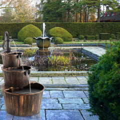 YI barrel fountain flowing water in use creating calming sound and visual movement outdoors