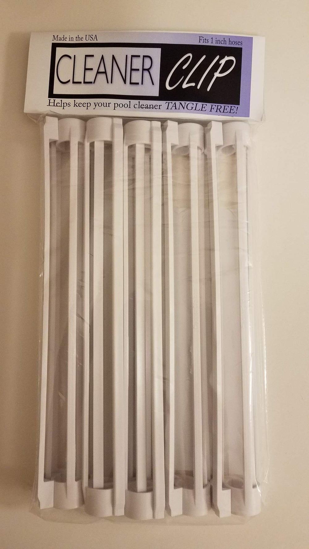 Zodiac Cleaner Clip next to ruler for scale, shows fit for 3/4 to 1 inch hoses